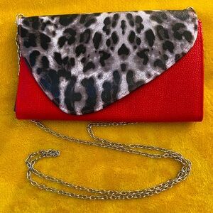 Clutch and crossbody bag. Red w/ animal print snap flap. Removal chain strap.